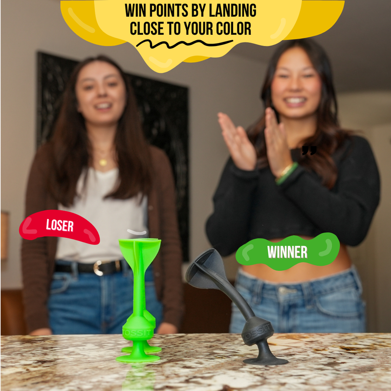 The winner celebrating after landing the black dart closest to their own color